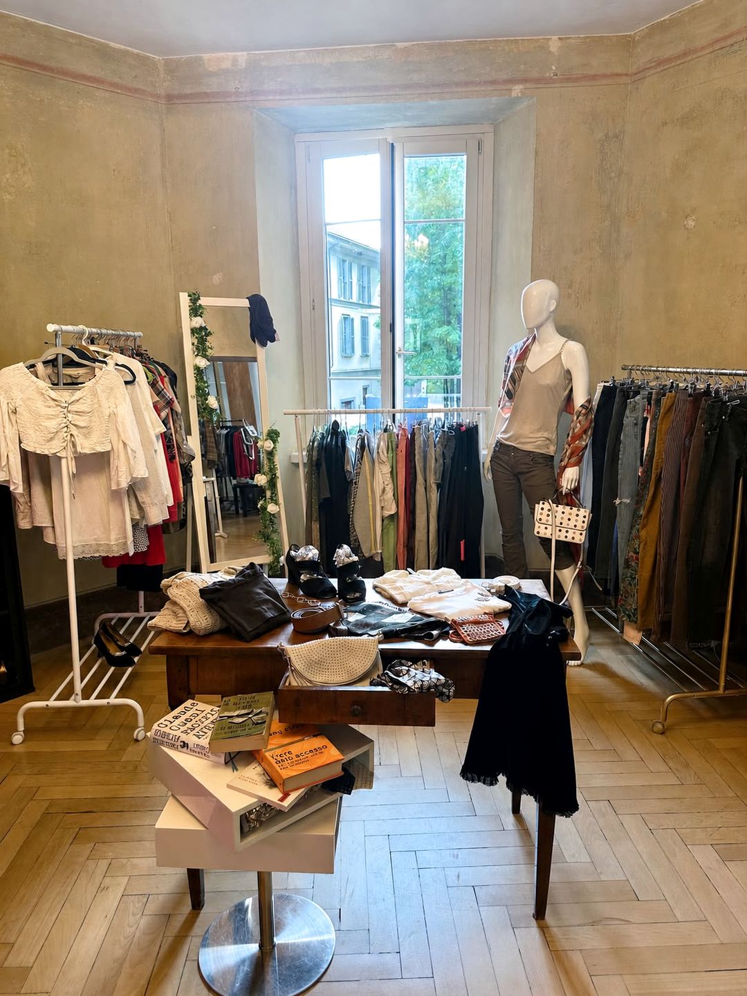 La boutique Autre Amour a Lugano: abiti, accessori e arredi in una stanza luminosa con pavimento in parquet.